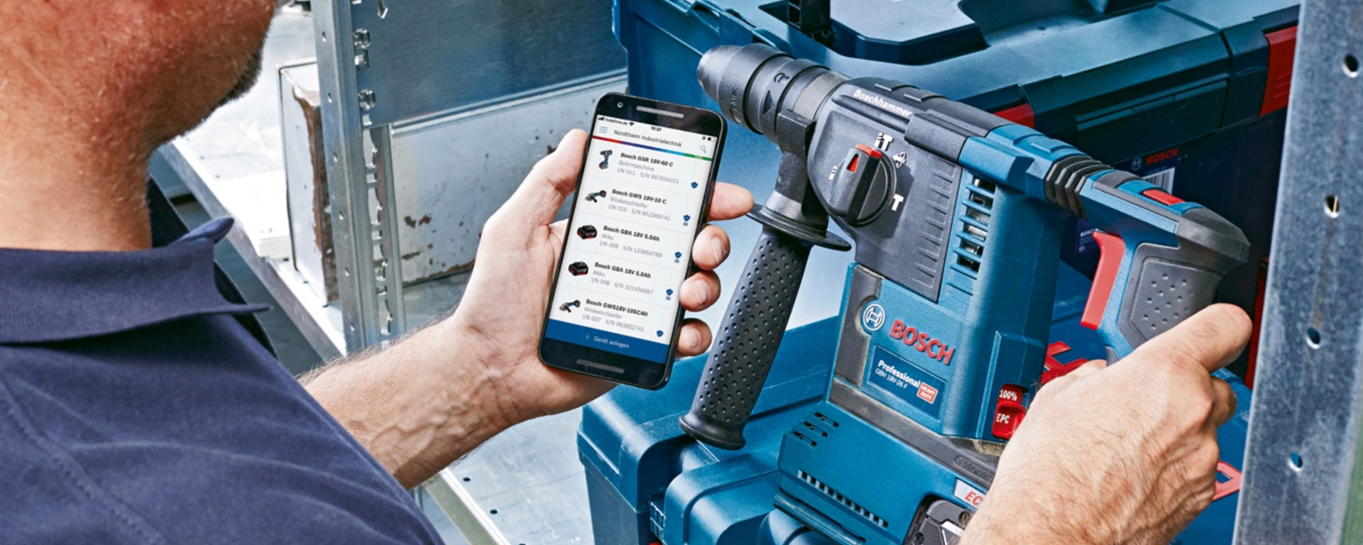 Man with Bosch hammer drill in his hand and PRO360 app on his smartphone.