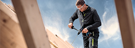 A craftsman is working with a Bosch tool on a roof.