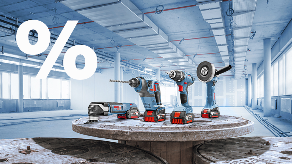 Five Bosch Professional tools on a table in an empty room.