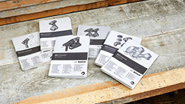 Six user manuals from Bosch Professional on a wooden surface.