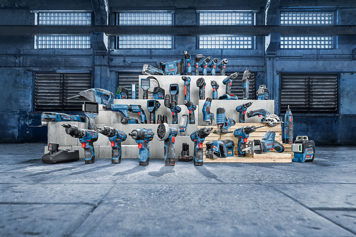 Bosch Professional tools in blue and black arranged on wooden shelves.