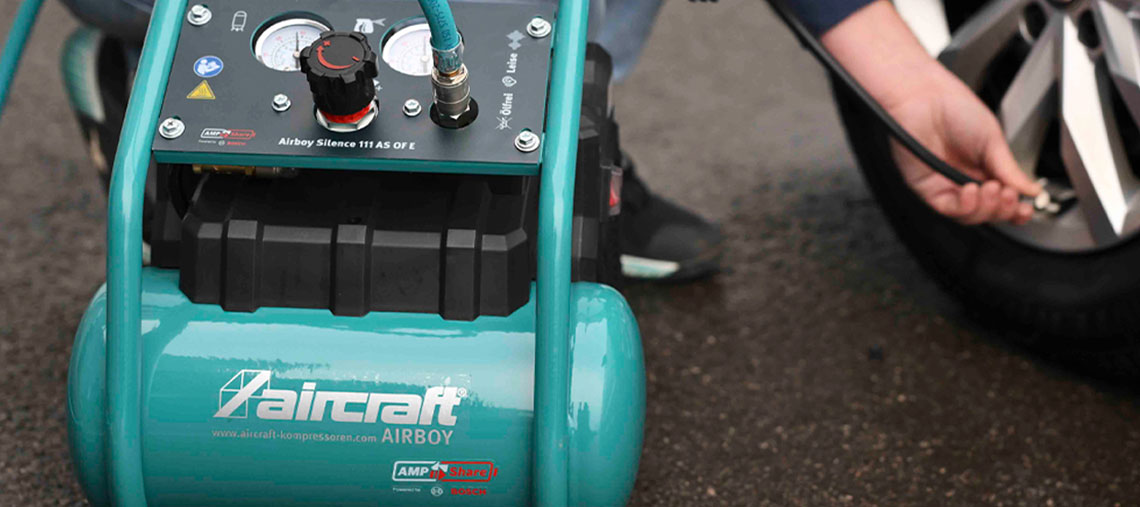 A green Aircraft Airboy compressor is used for inflating tires.
