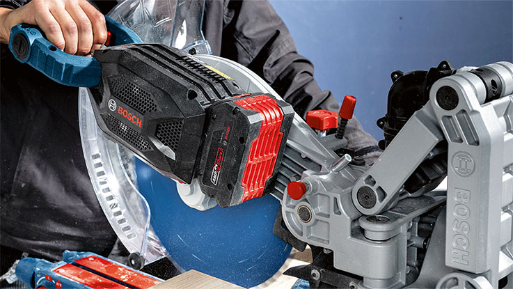 A Bosch Professional cordless circular saw is cutting wood.