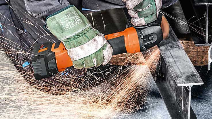 An orange Bosch Professional angle grinder produces sparks.