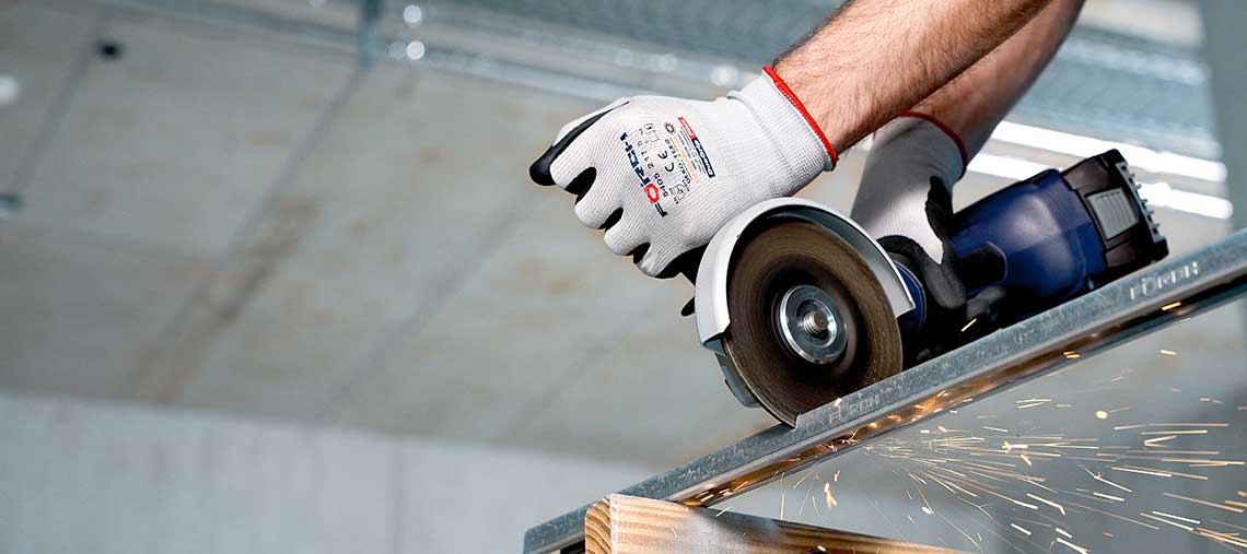 A craftsman is cutting metal with a blue Bosch Professional cutting machine.