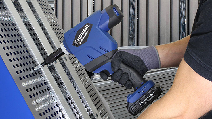 A blue HONSEL battery nailer is being used on a metal profile.