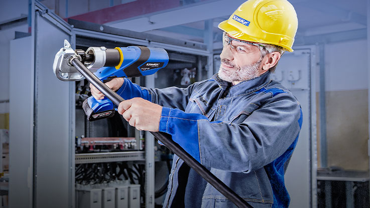 A man in a helmet uses a Bosch tool in a workshop.