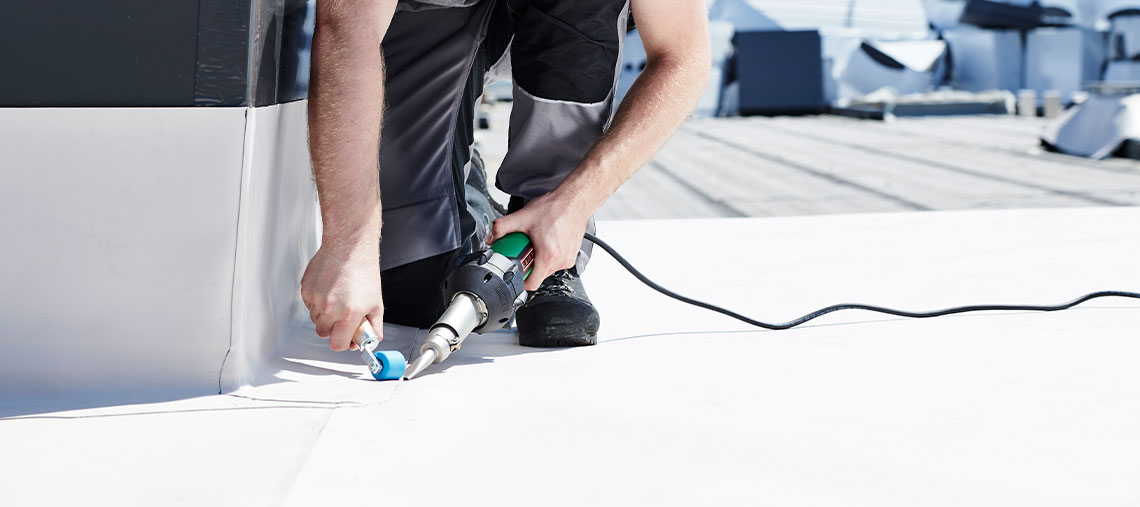 A craftsman uses a Bosch Professional tool on a roof surface.