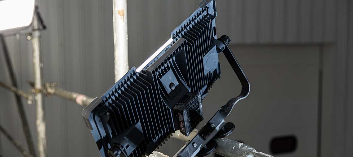 A black Bosch Professional LED light stands on a scaffold.