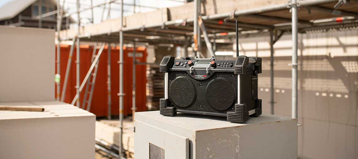A black Bosch Professional construction radio is standing on a box.