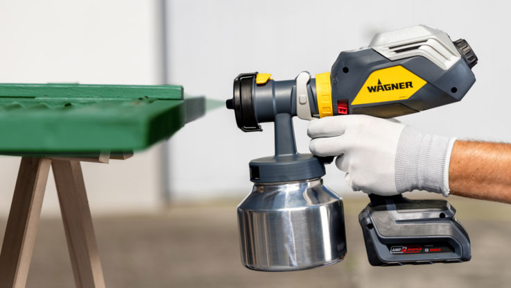 A Wagner sprayer is used on a green surface.