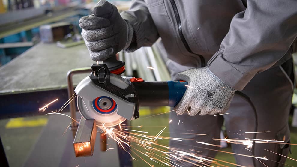 A Bosch Professional angle grinder produces sparks when cutting.