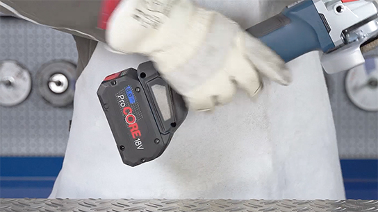 A person is holding a Bosch ProCORE 18V battery in their hand.