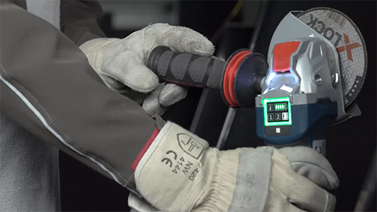 A craftsman uses a Bosch Professional angle grinder with a display.