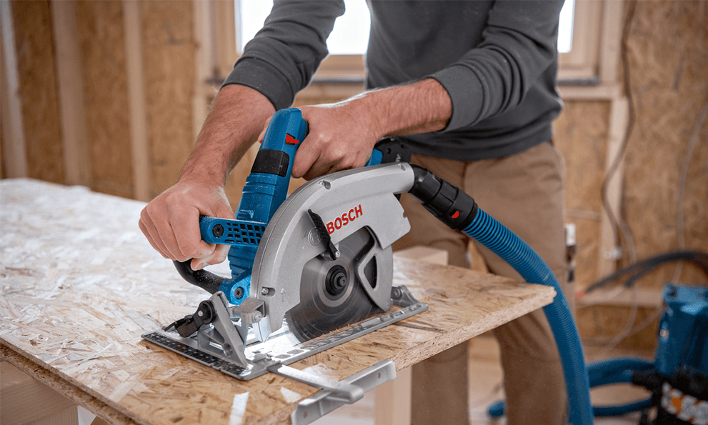 A Bosch Professional circular saw is being used on a wooden board.