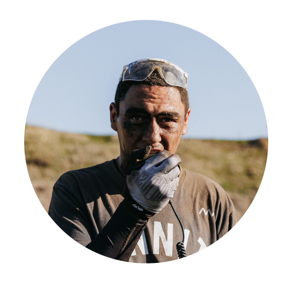 A man with gloves is speaking into a radio, dirty and active.