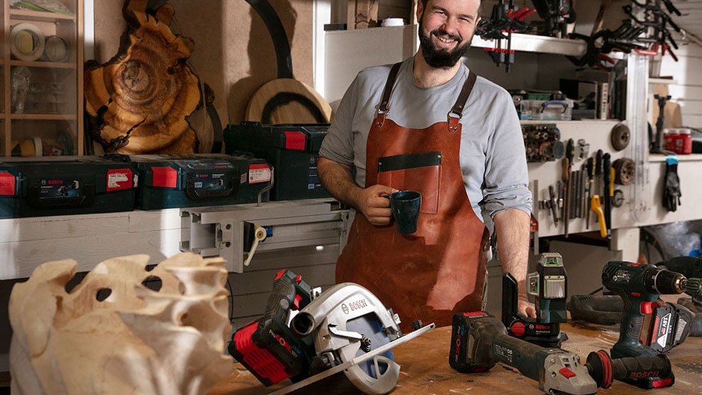 A bearded craftsman in a workshop, surrounded by Bosch tools.