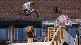 A mountain biker jumps over a wooden ramp at RedBull District Ride.