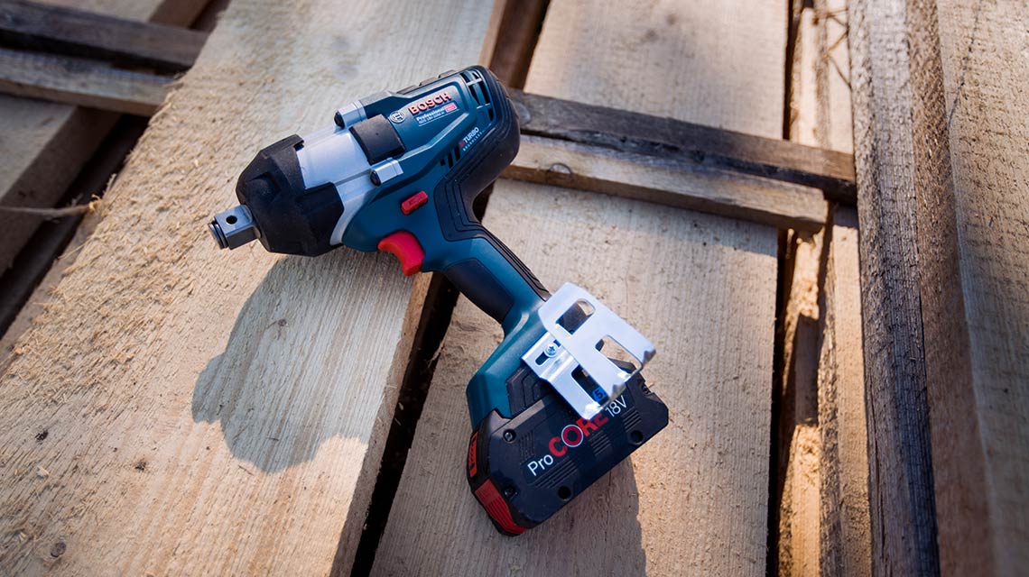 A Bosch Professional cordless tool is lying on wooden planks.