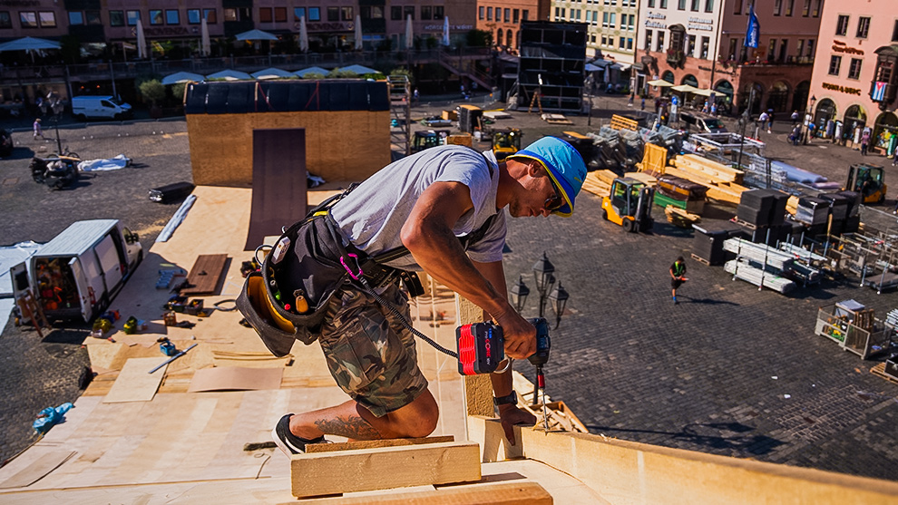 Stop motion shot of Emil Johansson on a slope built with Bosch Professional tools A craftsman with a blue hat is drilling into wood at a construction site.