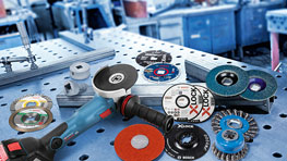 A Bosch Professional angle grinder is placed next to various grinding discs.